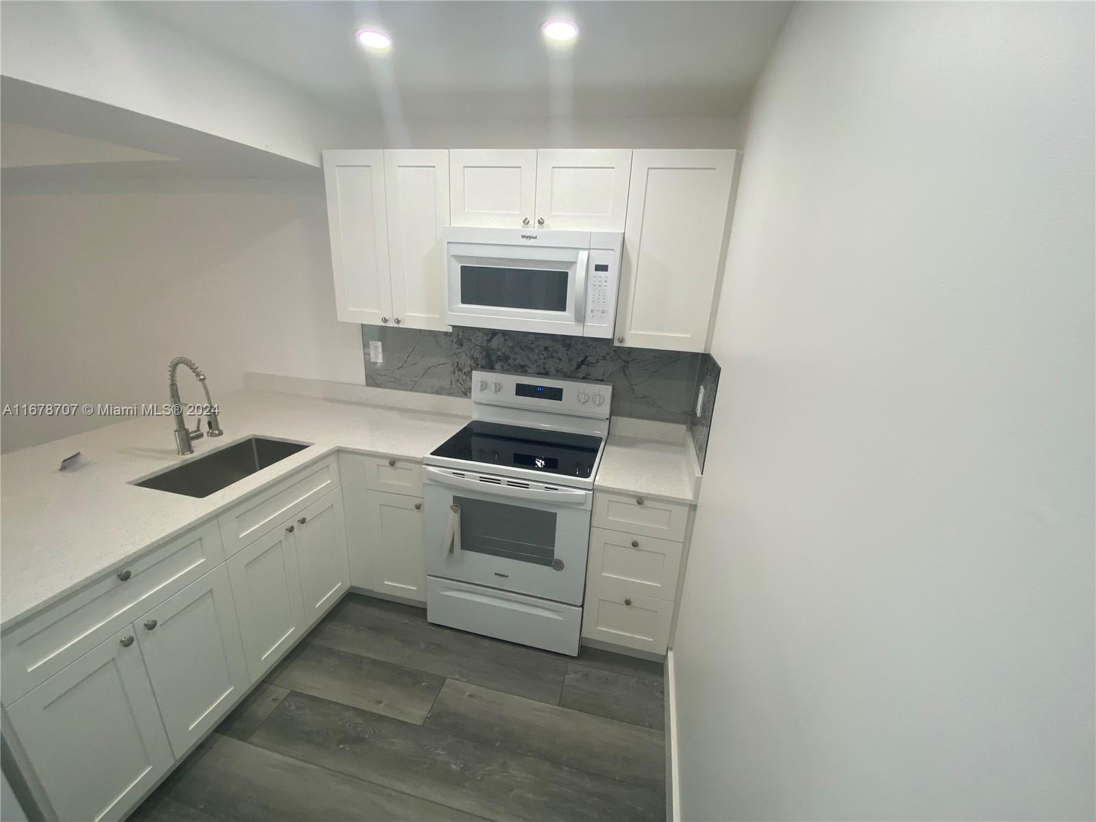 a kitchen with a sink stove and microwave