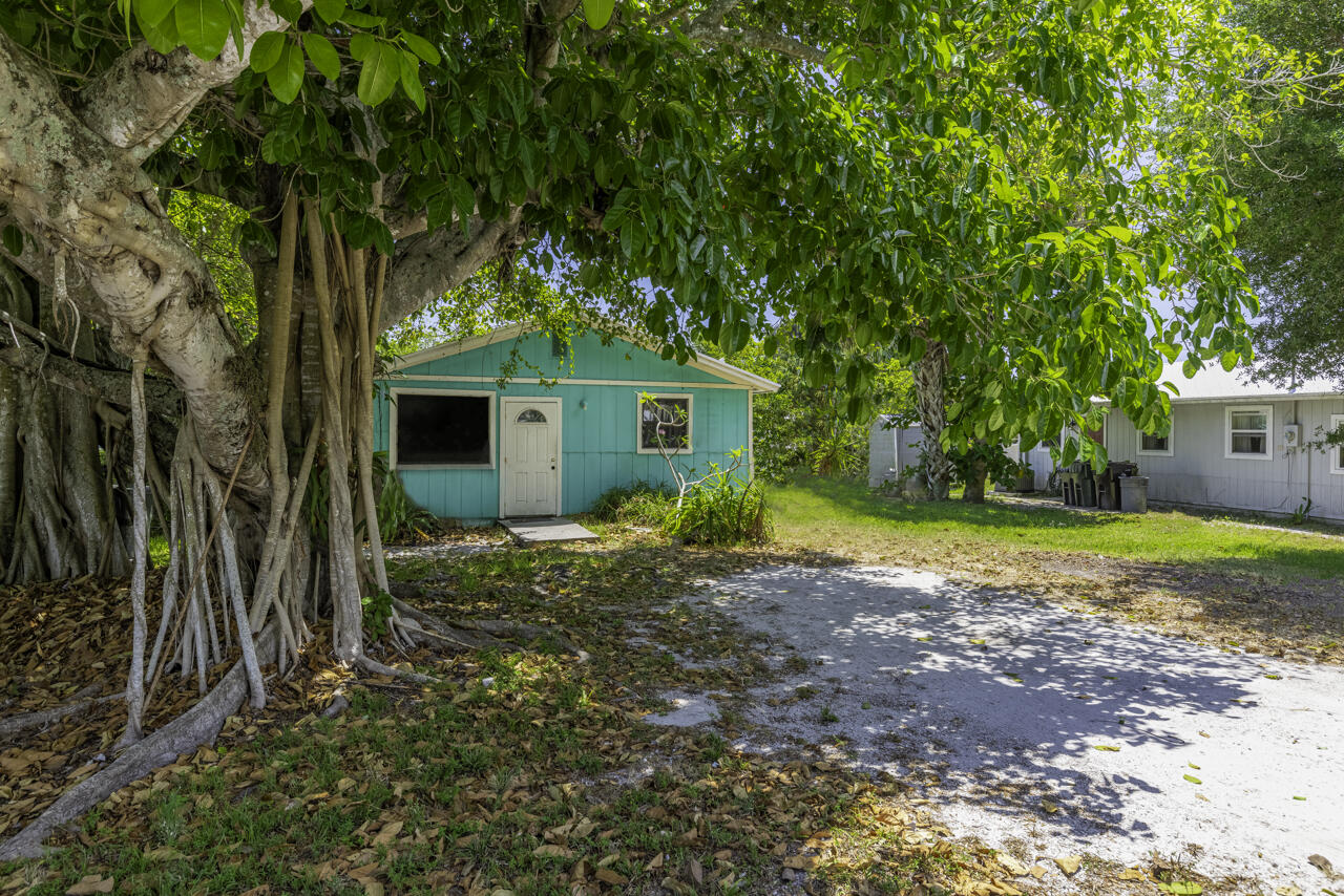 a view of a house with backyard and tree s