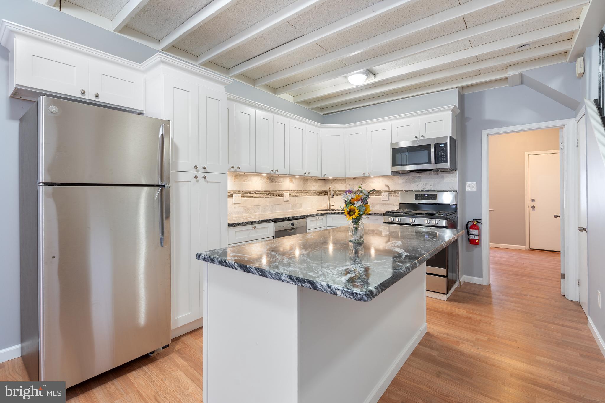 a kitchen with kitchen island a counter top space a sink and a refrigerator