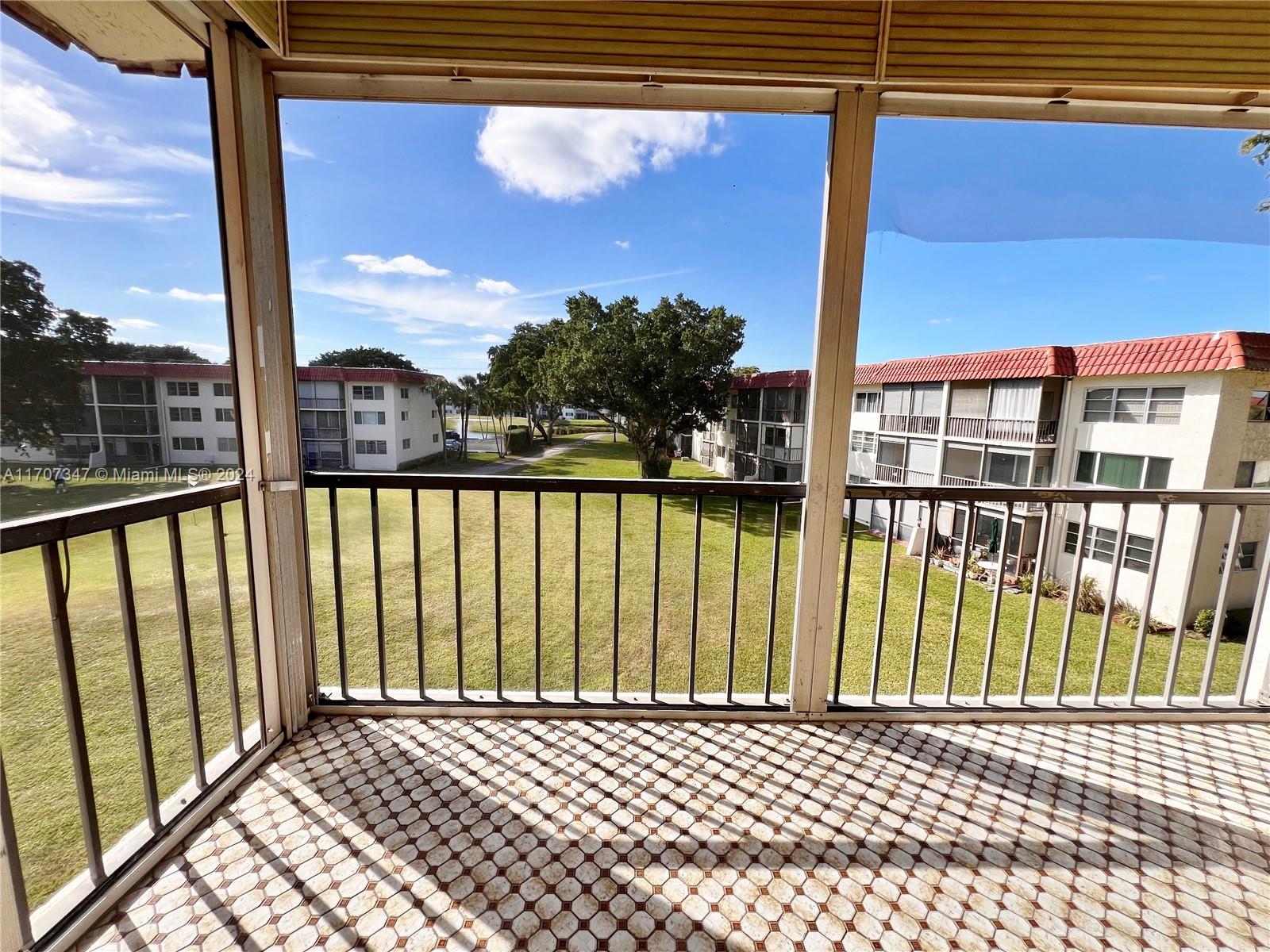 a view of a balcony with a floor to ceiling window next to a brick wall