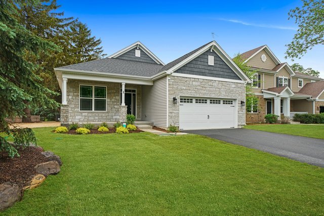 a view of a house with a big yard and large tree