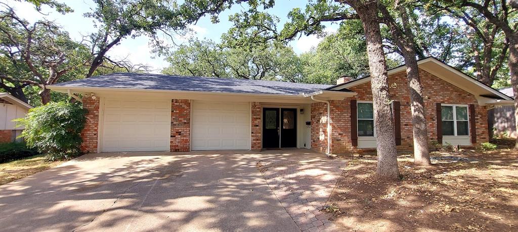 a front view of a house with a tree in front