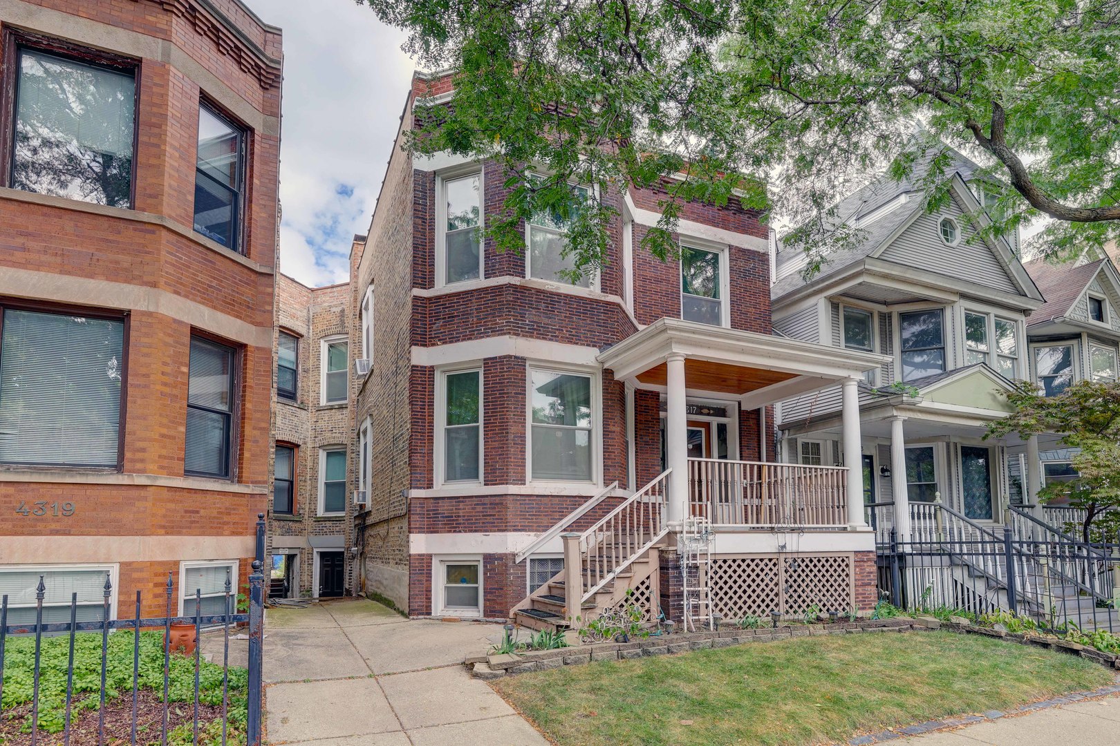 a front view of a residential apartment building with a yard