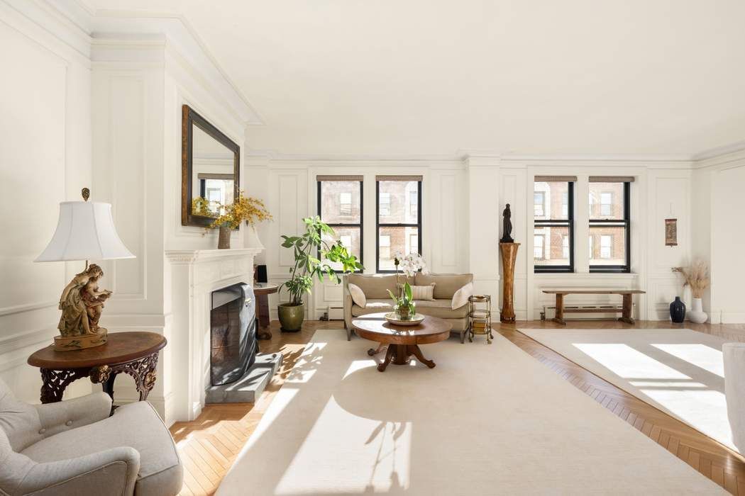 a living room with furniture a fireplace and large windows