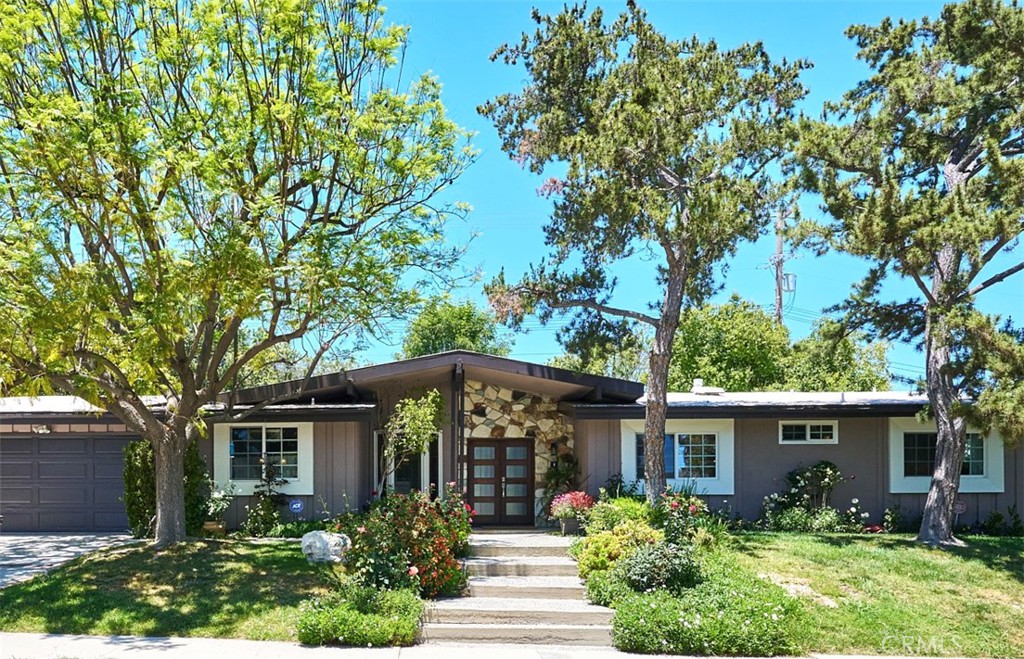 a front view of house with yard and trees