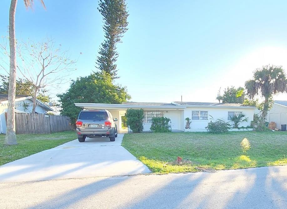 a front view of a house with a garden and yard