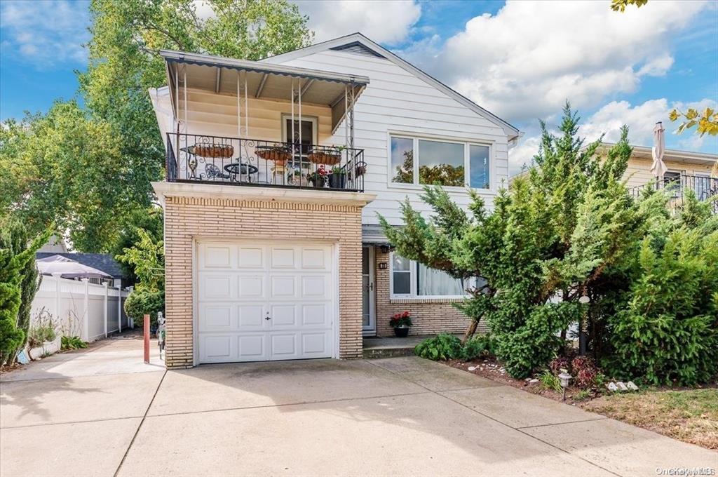 View of front of property featuring a balcony and a garage