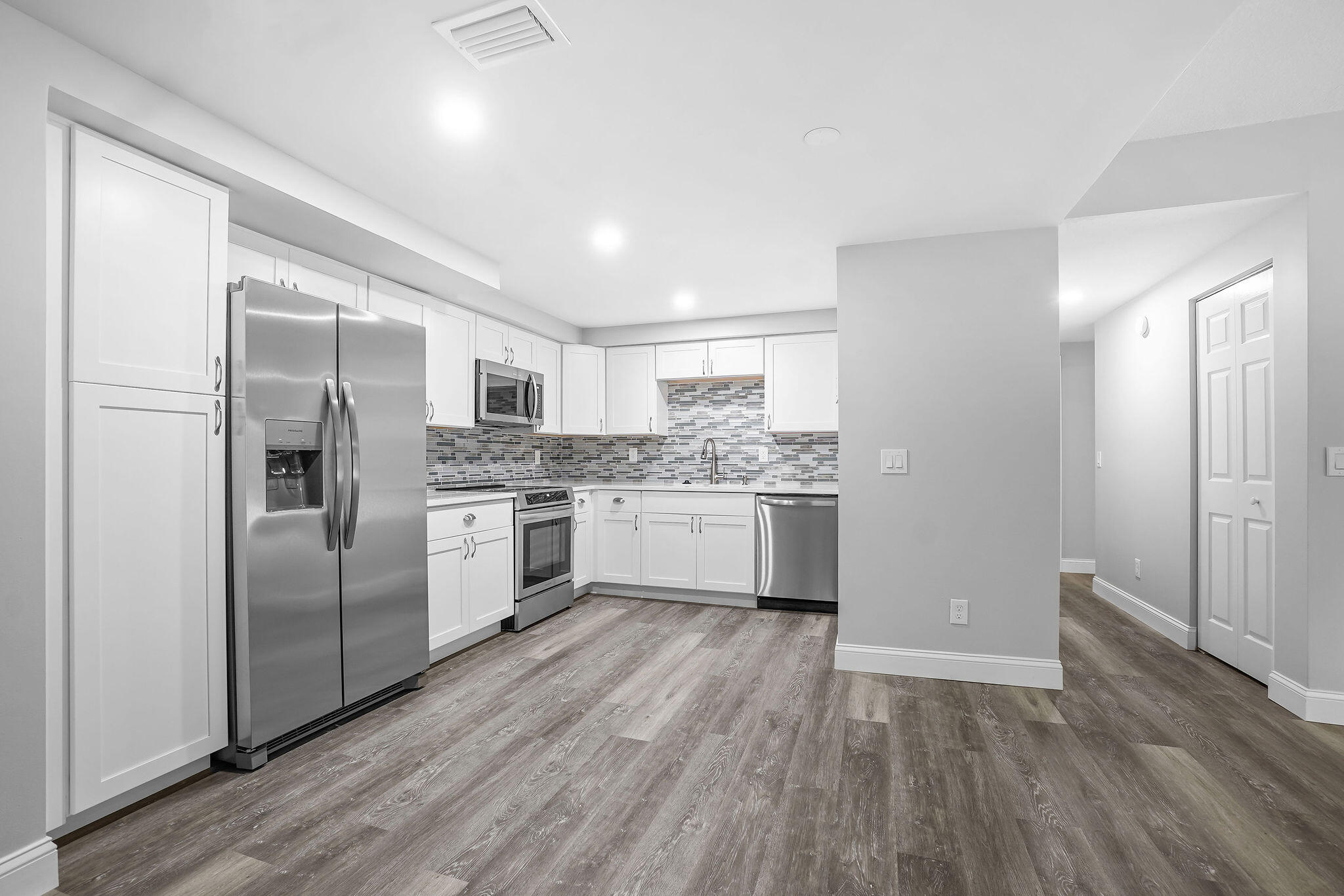 a kitchen with white cabinets and stainless steel appliances