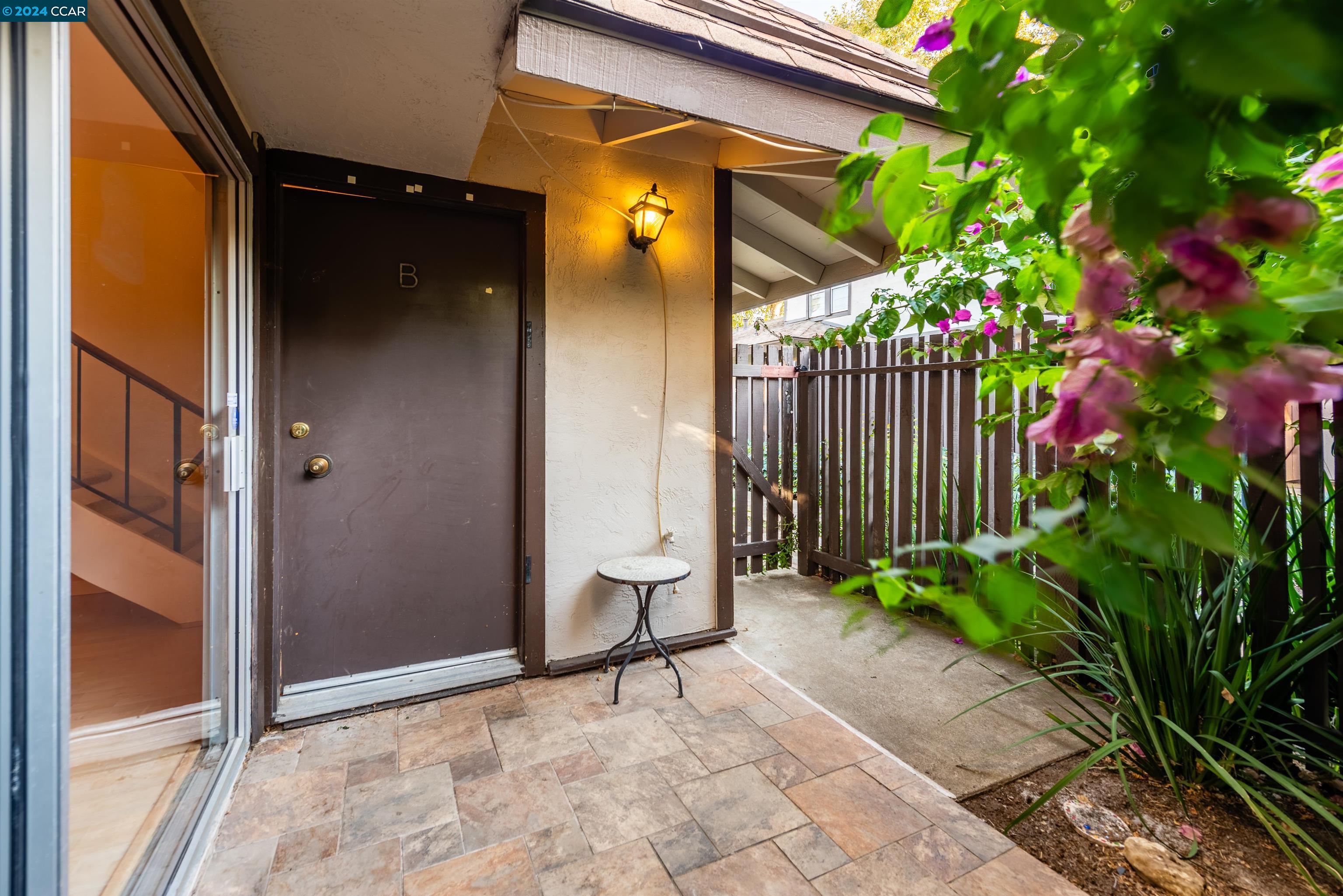 a view of a door with a bench and potted plants