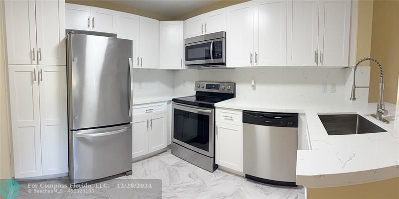 a kitchen with a refrigerator sink and microwave