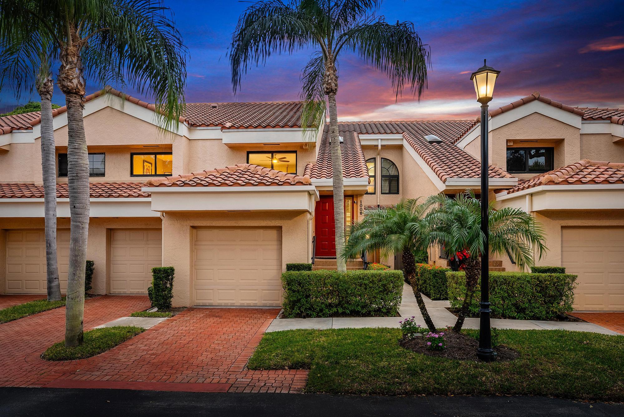 a view of a house with a yard and palm trees