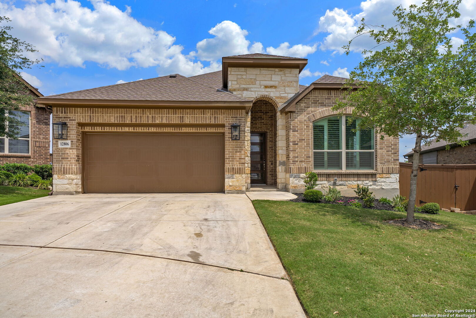 a front view of a house with a garden and yard