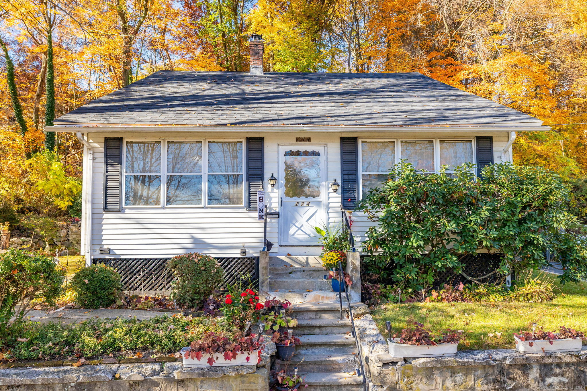 a front view of a house with a yard and potted plants