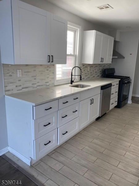 a kitchen with granite countertop a sink and cabinets