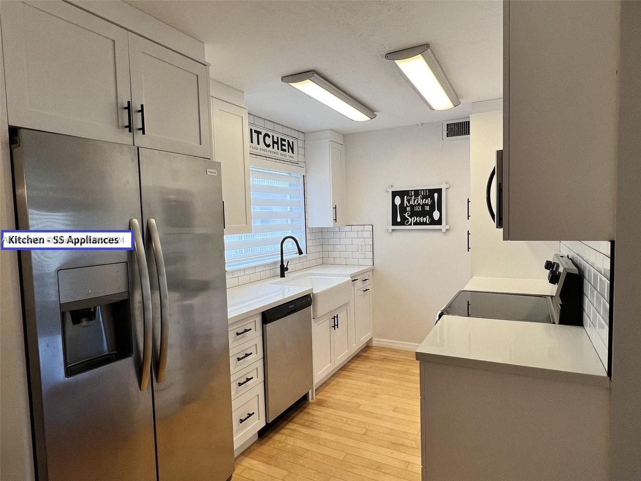 a kitchen with stainless steel appliances granite countertop a sink and a refrigerator