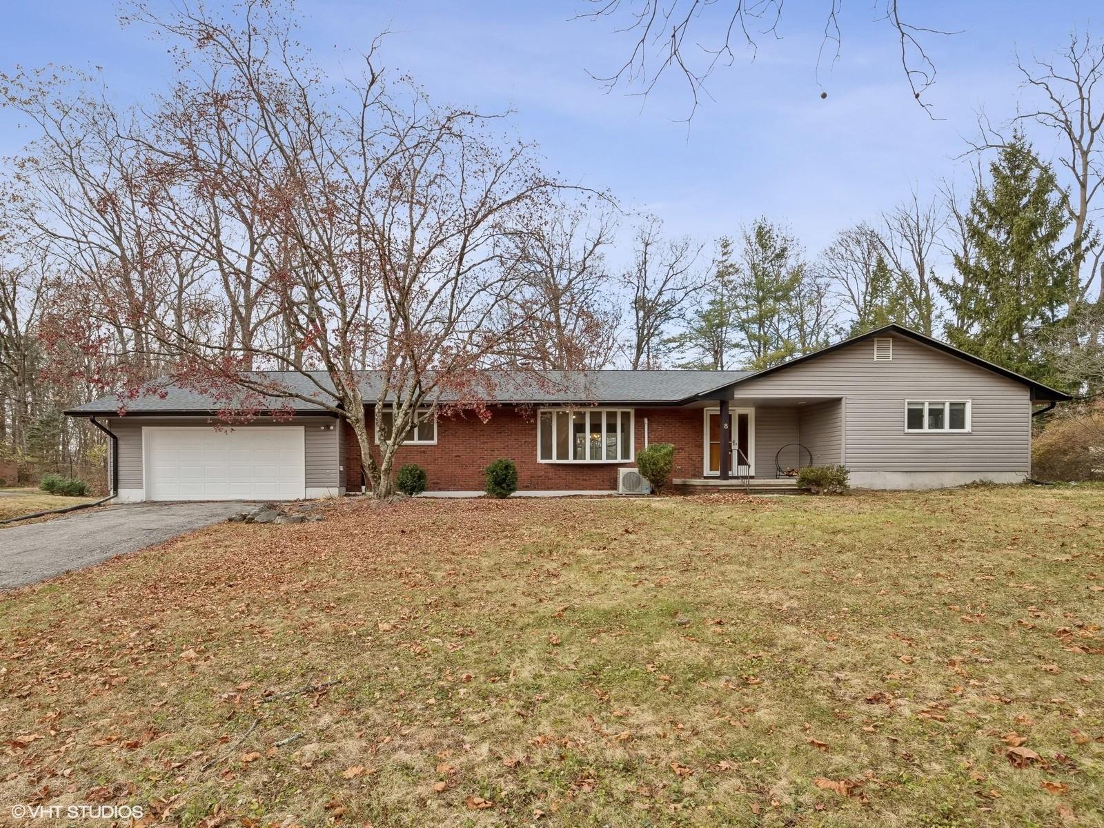 Ranch-style home featuring a garage and a front lawn