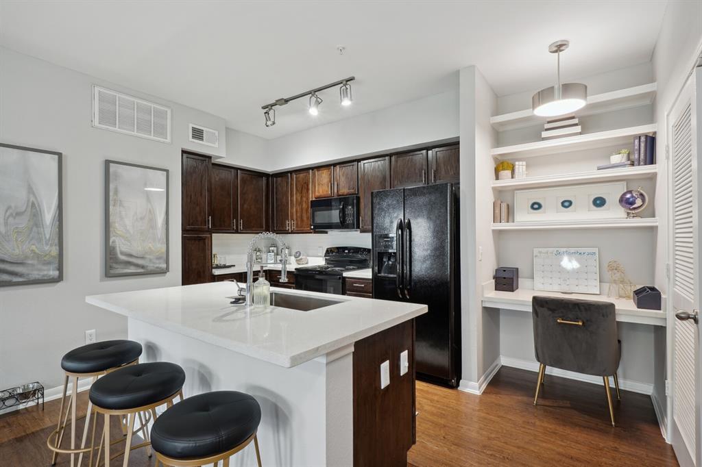 a kitchen with kitchen island a sink stove and refrigerator