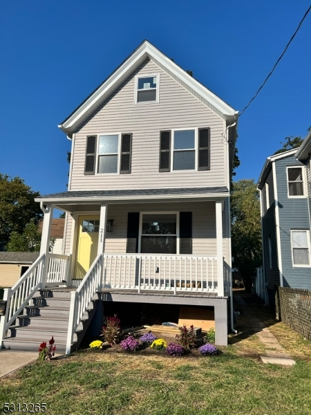 a front view of a house with yard and staircase