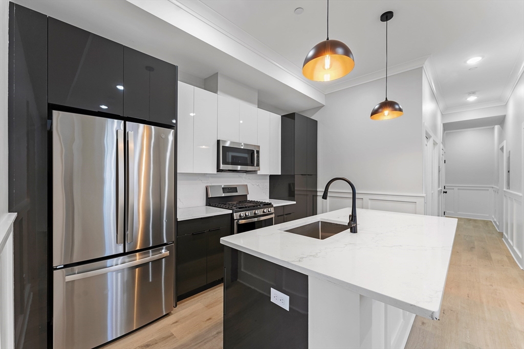 a kitchen with a refrigerator a sink and cabinets