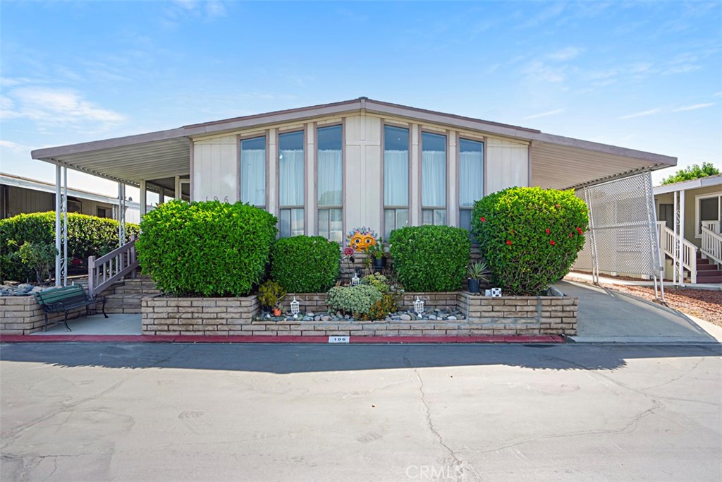 a front view of a house with garage and plants