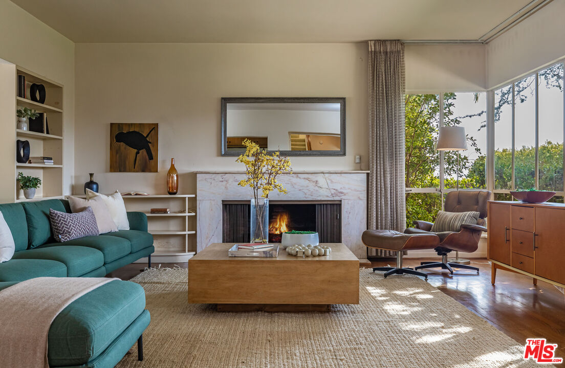 a living room with furniture fireplace and a large window