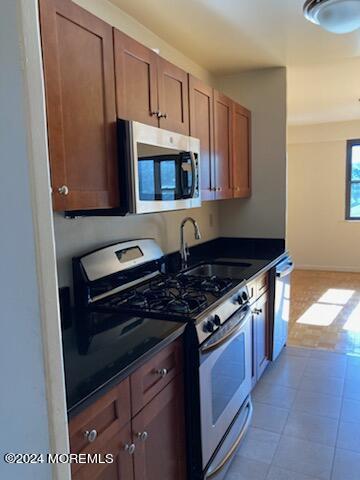 a kitchen with stainless steel appliances granite countertop a stove and a microwave