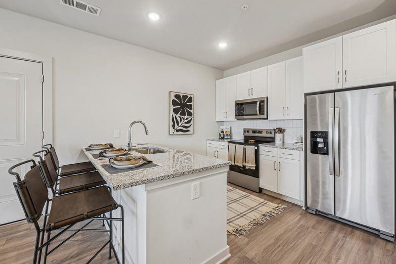 a kitchen with stainless steel appliances granite countertop a stove refrigerator sink and cabinets