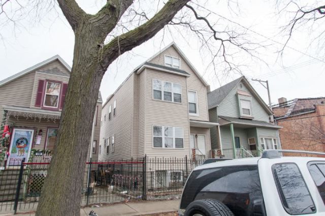 a view of a house with a cars park side of a road