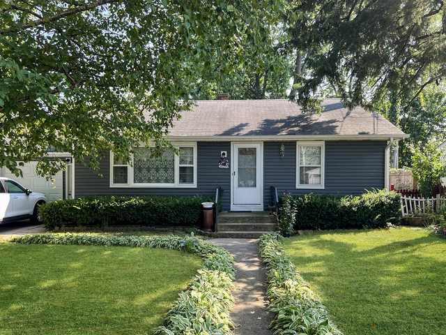 a front view of a house with a yard and outdoor seating