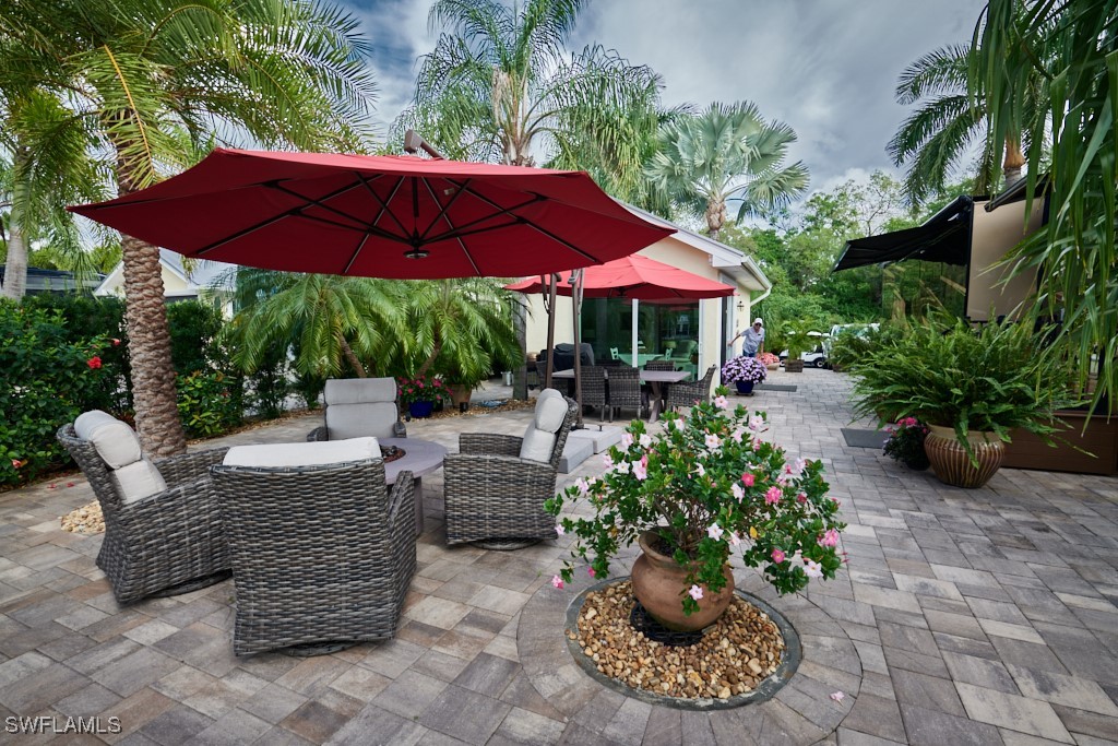 a view of a patio with chairs and flower plants