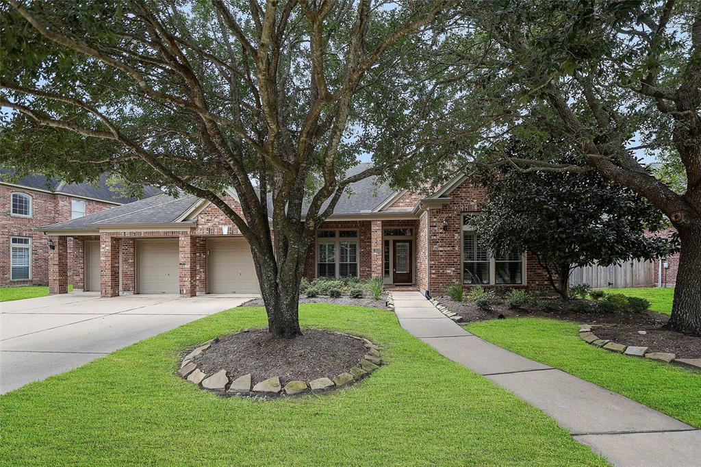 a front view of a house with a yard and trees