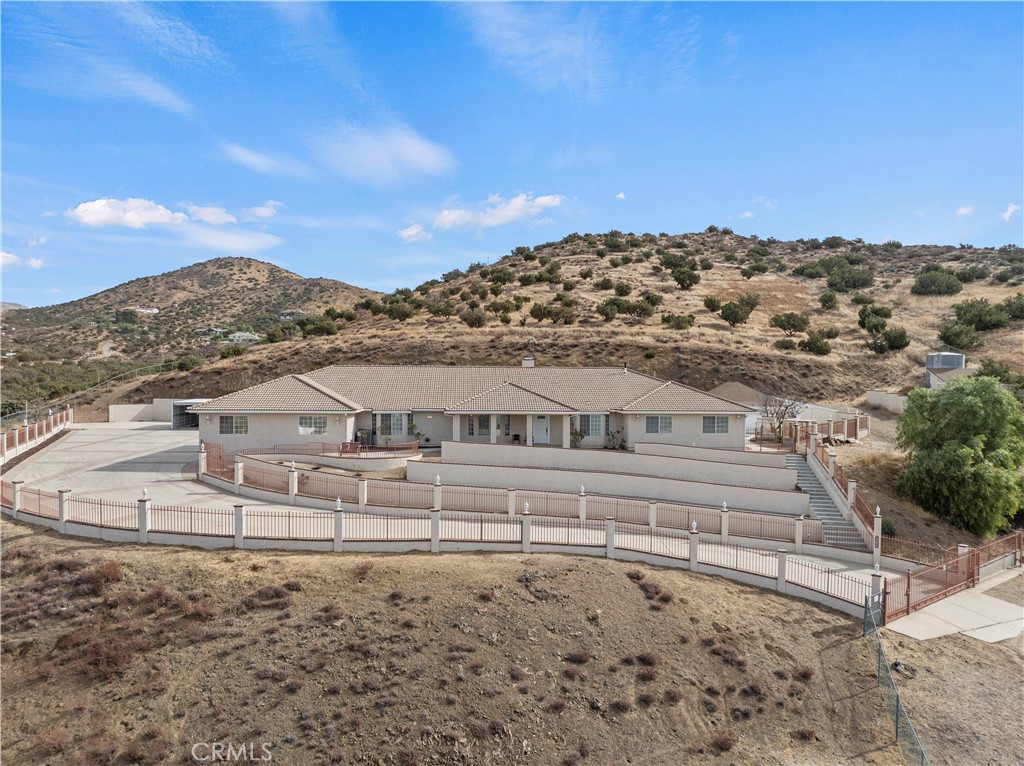 a view of a large white house with a yard and mountain view