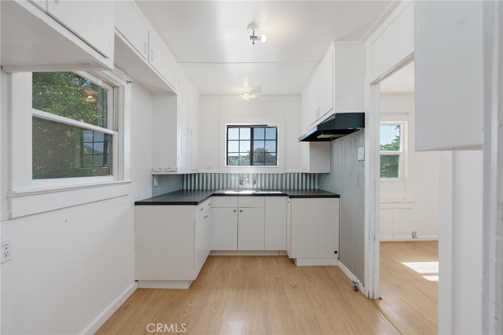 a kitchen with stainless steel appliances granite countertop a sink and a stove next to a window