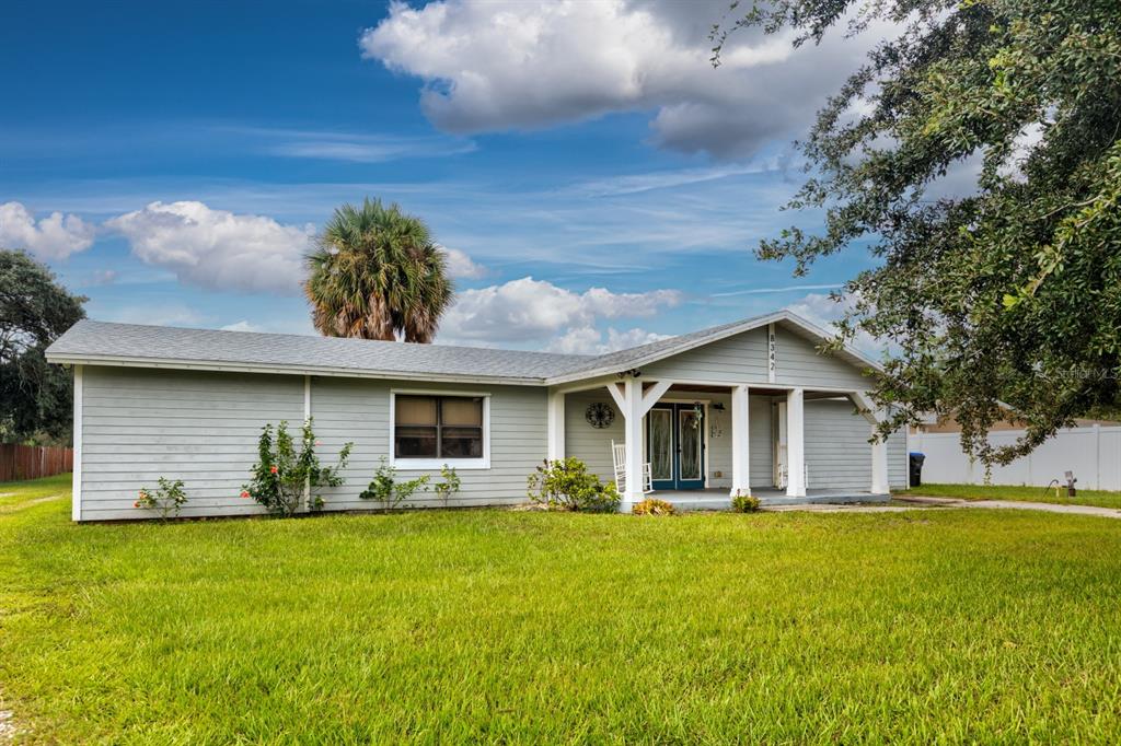 a front view of house with yard and trees in the background