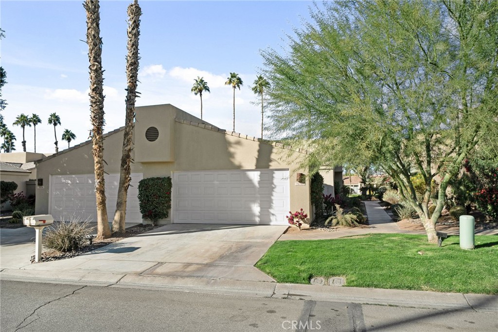 a front view of a house with a yard and trees