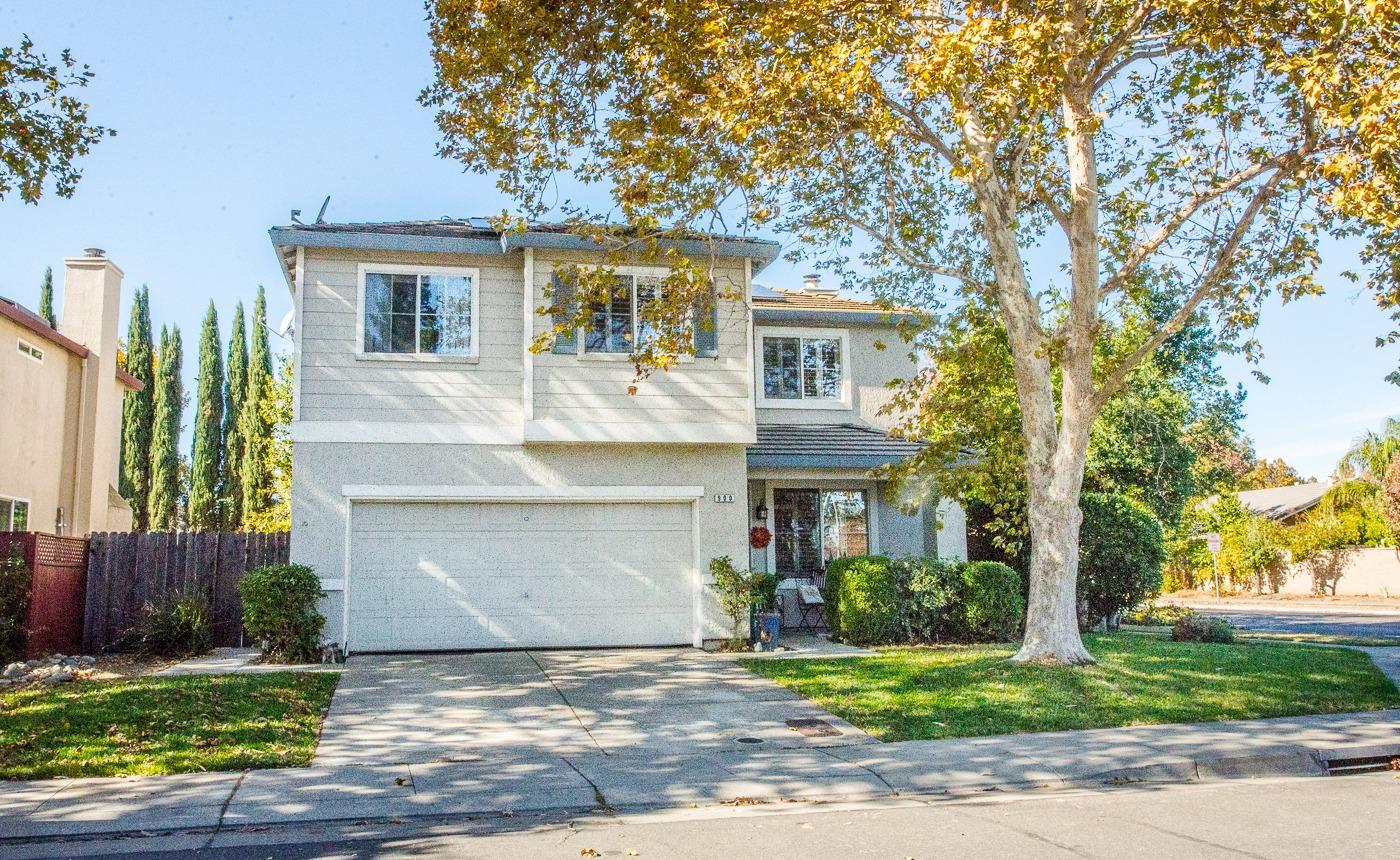 a front view of a house with a yard and a garage