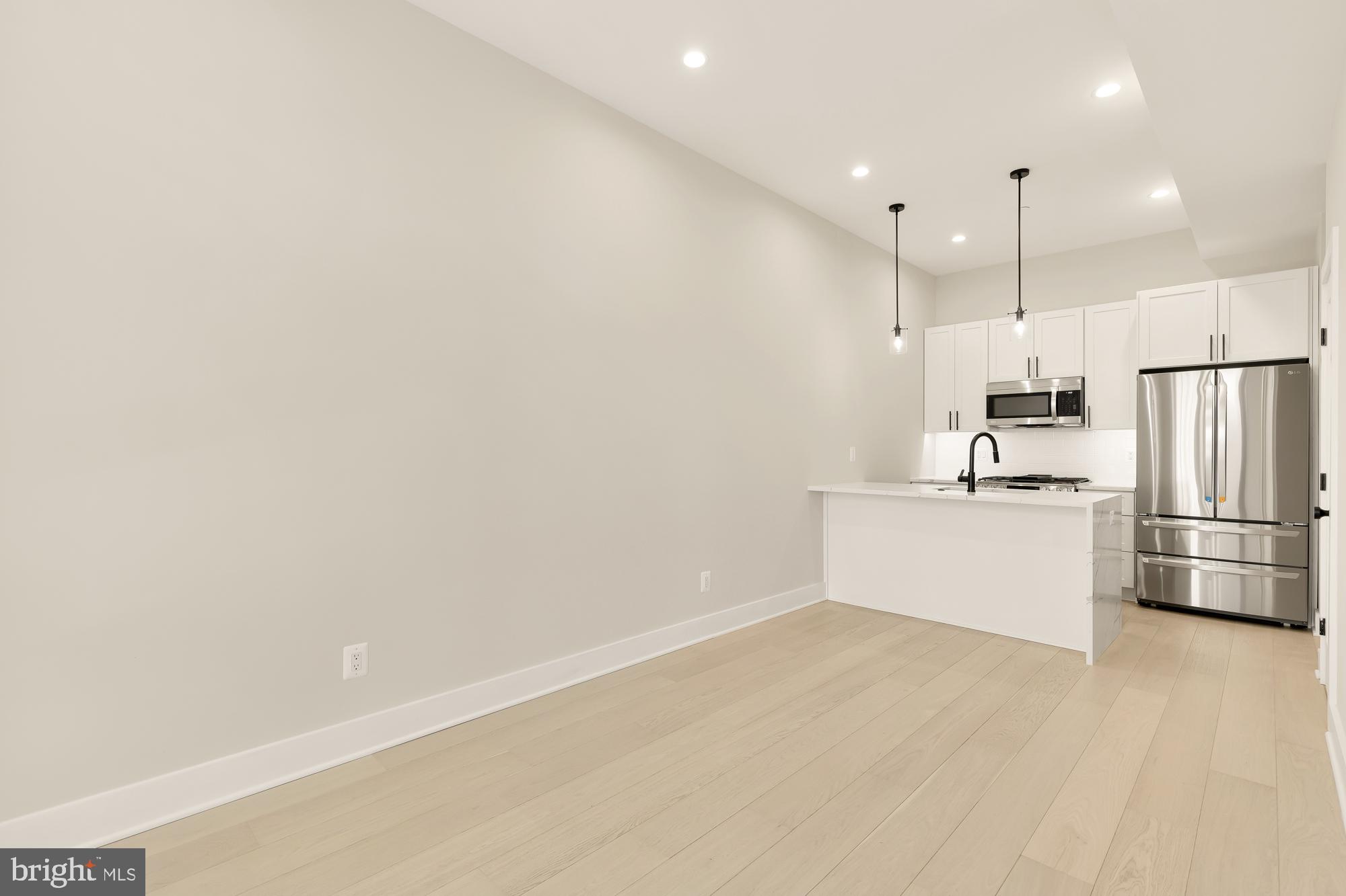 a view of kitchen with white cabinets and white stainless steel appliances