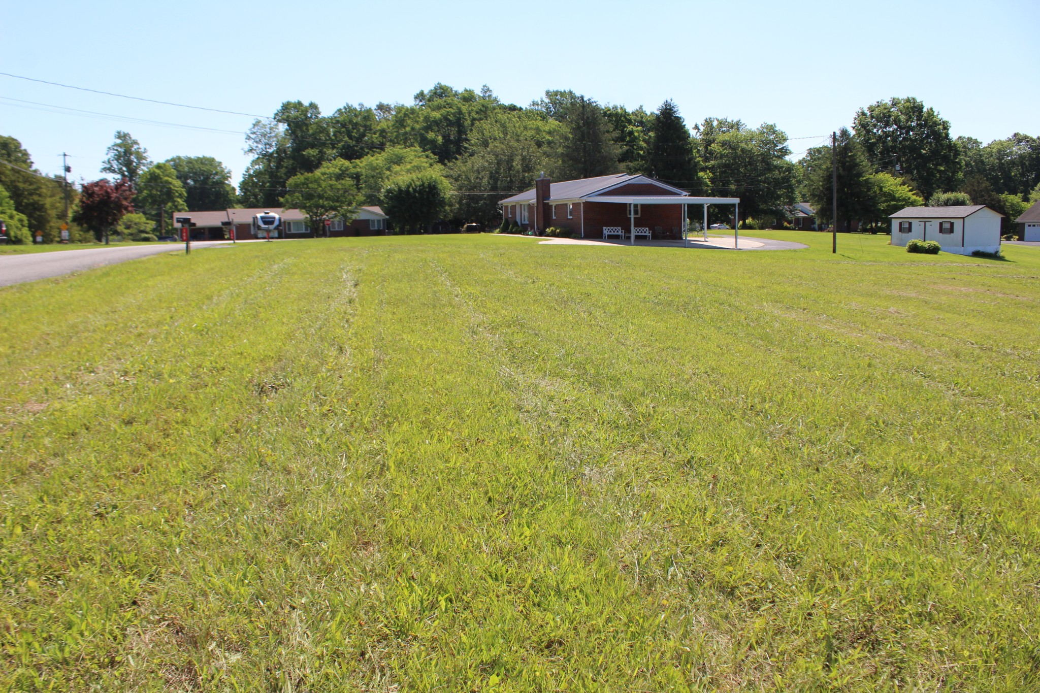 a blue swimming pool is in middle of the green field