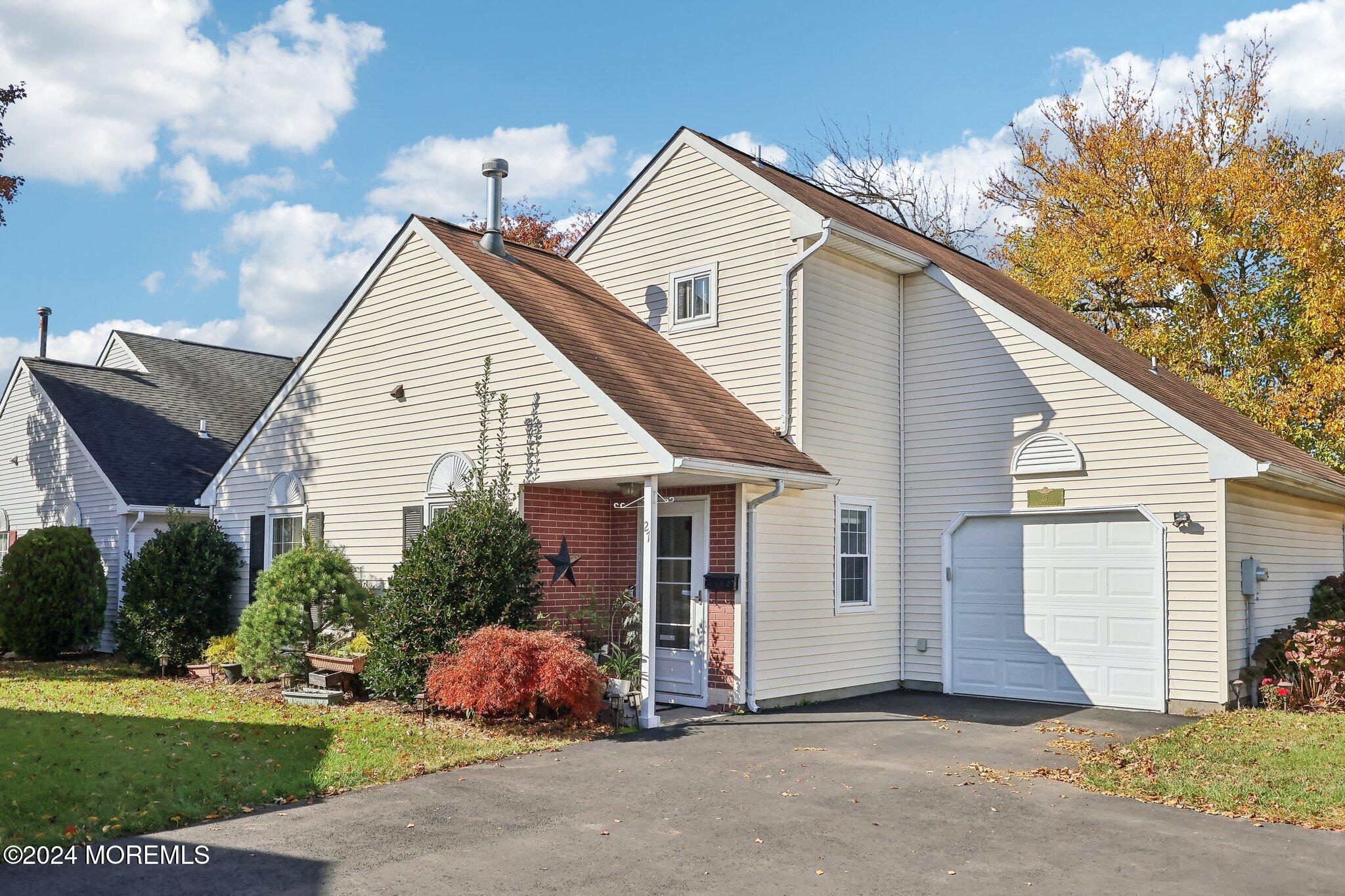 a view of a house with a yard and potted plants