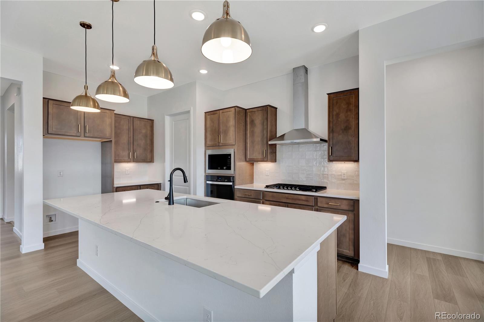 a kitchen with stainless steel appliances granite countertop a stove a sink and a wooden floors