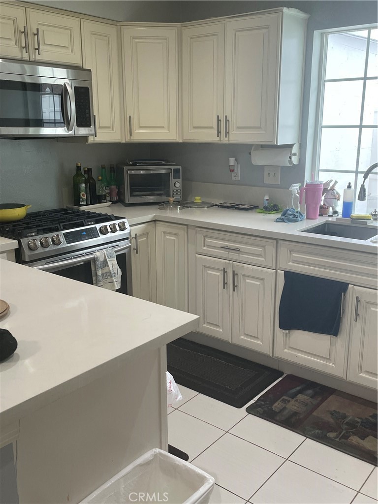 a kitchen with cabinets appliances a sink and a window