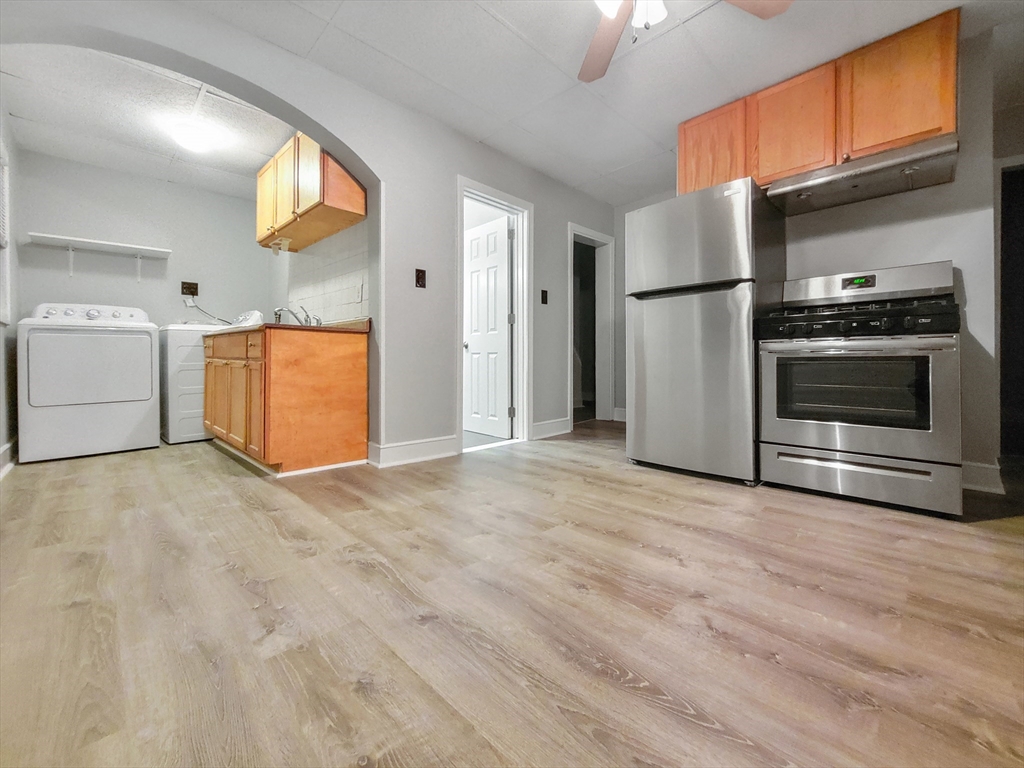 a view of a kitchen with a sink a refrigerator and window