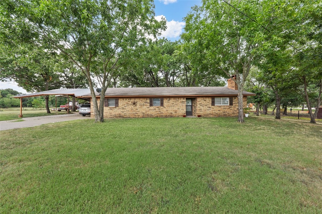 a view of house with yard and sitting area