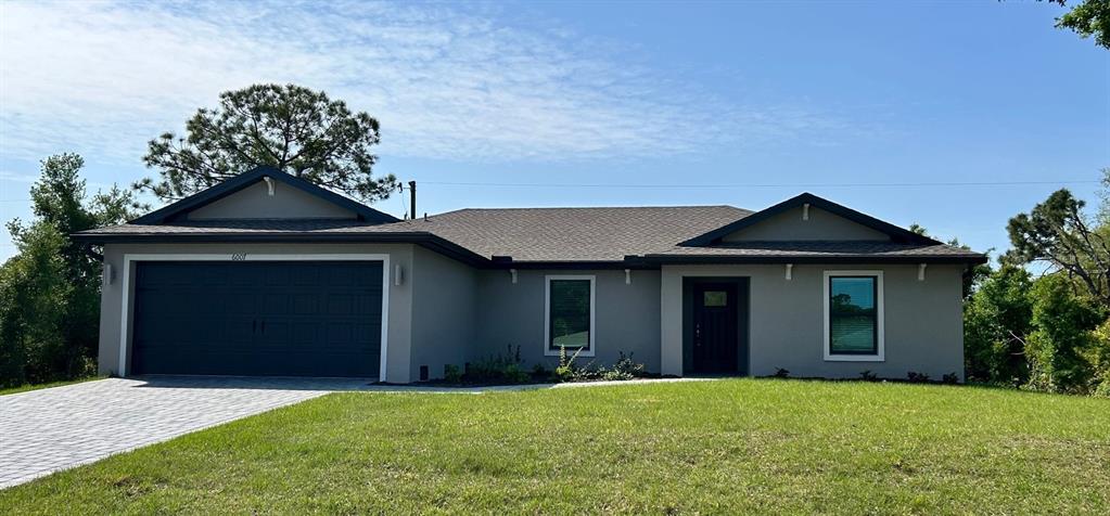 a front view of a house with a yard and garage