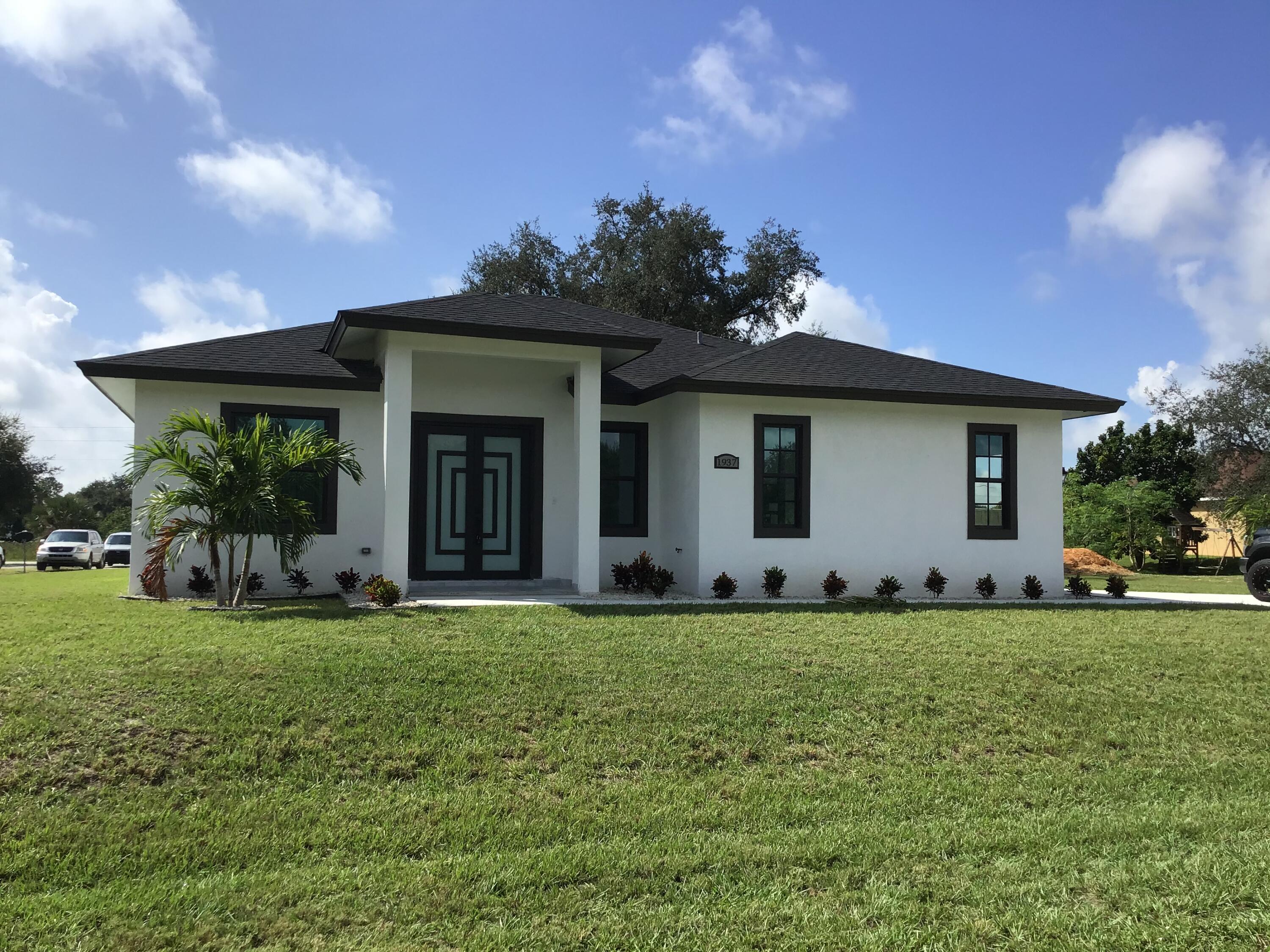 a view of a house with a yard and potted plants