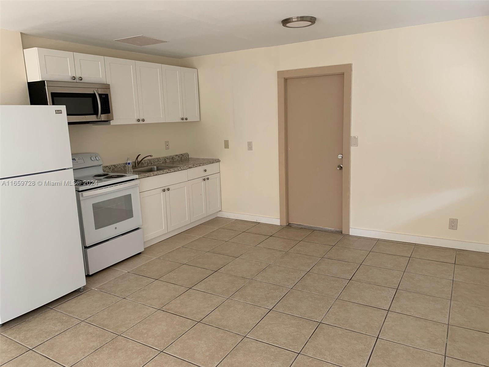 a kitchen with granite countertop white cabinets and stainless steel appliances