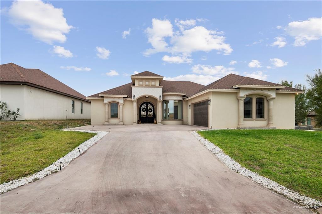 Mediterranean / spanish-style house featuring a garage and a front yard