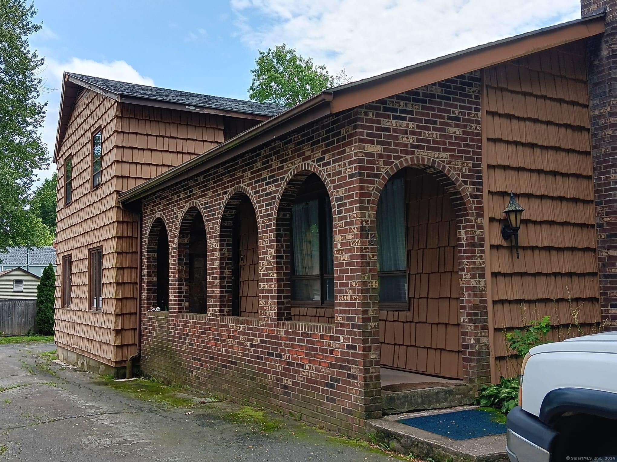 a front view of a house with a garden