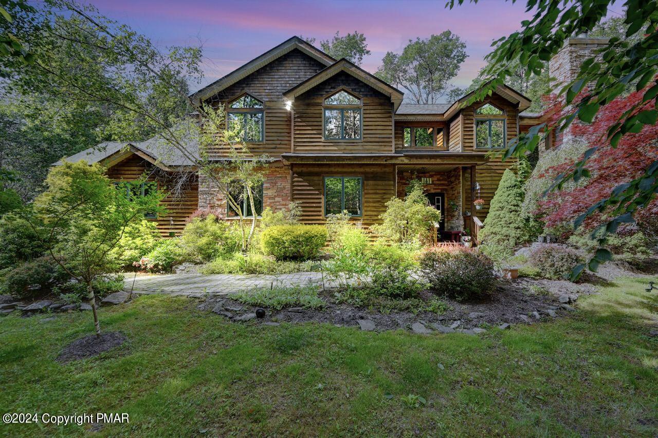 a front view of a house with a yard and potted plants