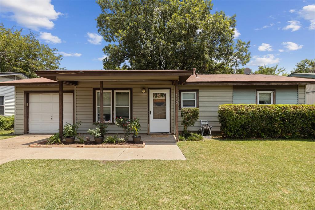 a front view of a house with a yard and potted plants